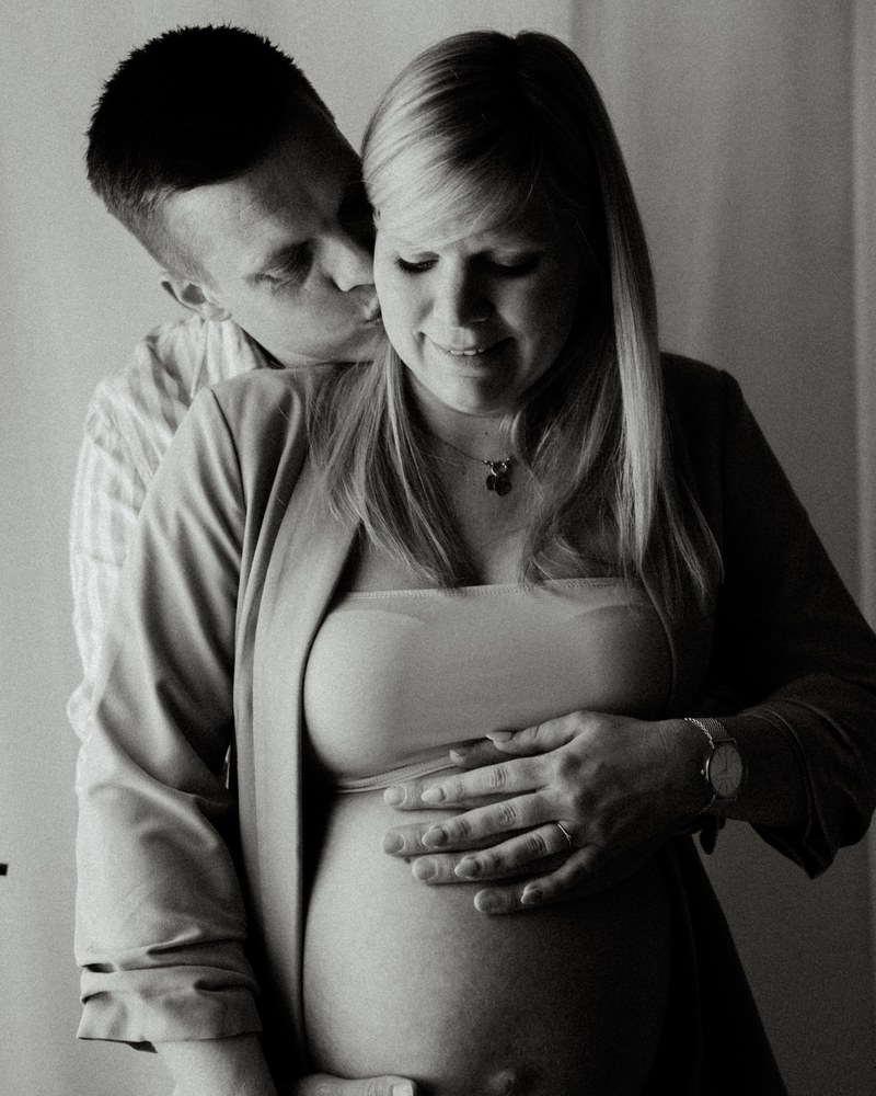 Schwangere Mutter und werdender Vater halten gemeinsam den Babybauch